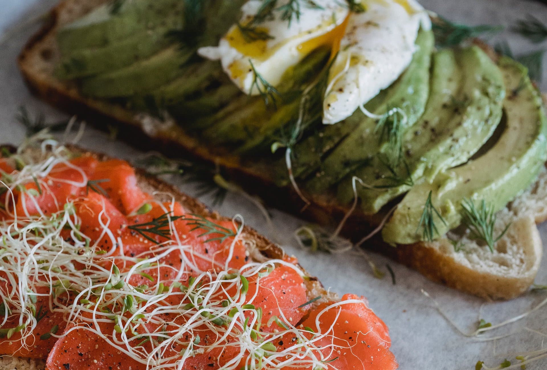 Toasts of avocado with egg and salmon: foods with healthy fats